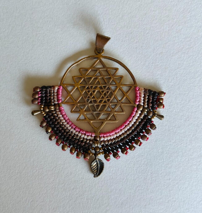 Carry a piece of ancient wisdom and positive energy with you wherever you go. This unique pendant features a handmade Sacred Geometry design in antique bronze, symbolizing harmony, balance, and the universe's intricate connection. The metal frame is lovin