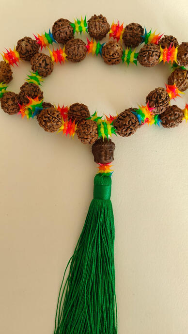 Embark on a journey of tranquility. This unique pendant blends sacred and surreal psychedelic elements. Handcrafted from pure bodhi seeds, a vintage wooden Buddha head, and vibrant star-shaped spacer beads, it's the perfect adornment for your car, yoga ma