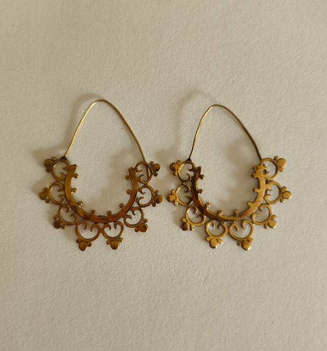 Let your ears bloom with these exquisite Indian-inspired brass earrings. Featuring a delicate hollow-out filigree pattern reminiscent of traditional Mughal architecture and Rajasthani craftsmanship, these earrings are lightweight yet eye-catching. The ant
