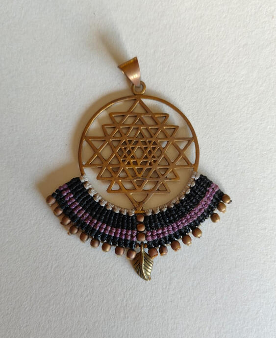 Carry the energy of the universe in a deeper, more mysterious tone. This Sacred Geometry pendant features the same powerful Sri Yantra-inspired design in antique bronze, but now wrapped in rich black and mystic purple waxed thread. The deep hues evoke int